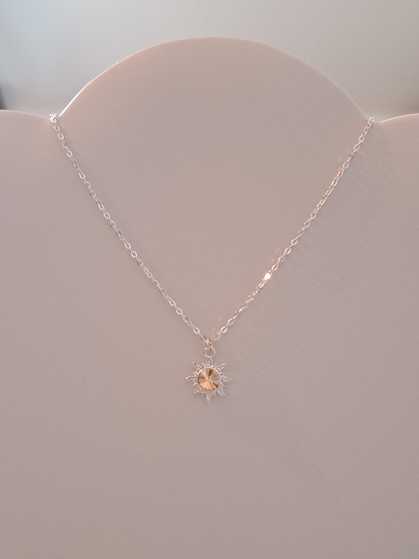 Collier en argent avec pendentif soleil orné d'un cristal doré
