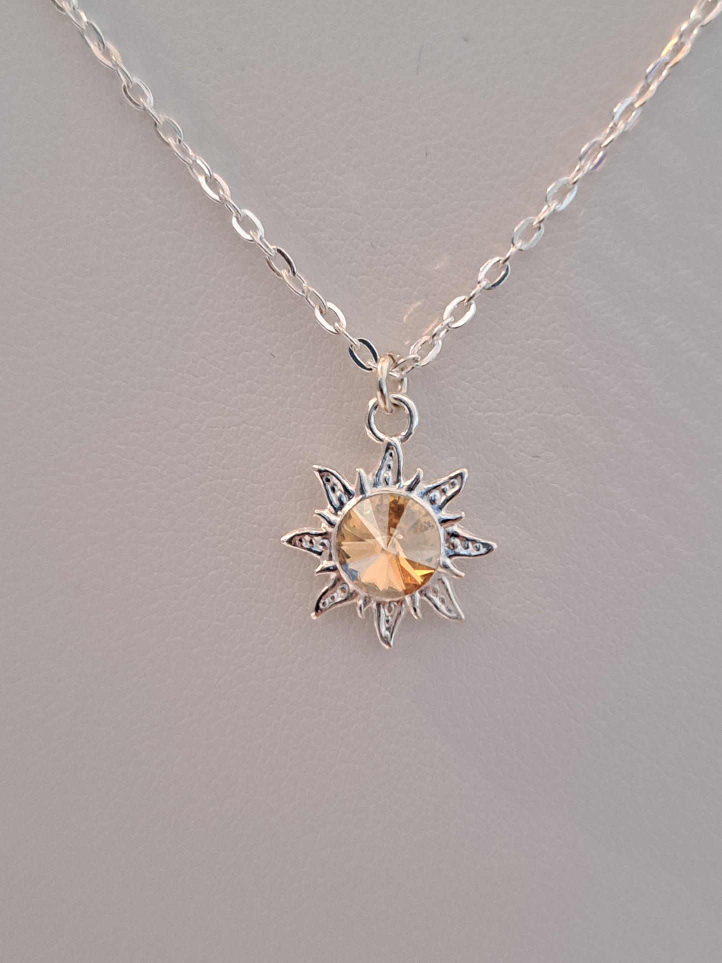Collier en argent avec pendentif soleil orné d'un cristal doré
