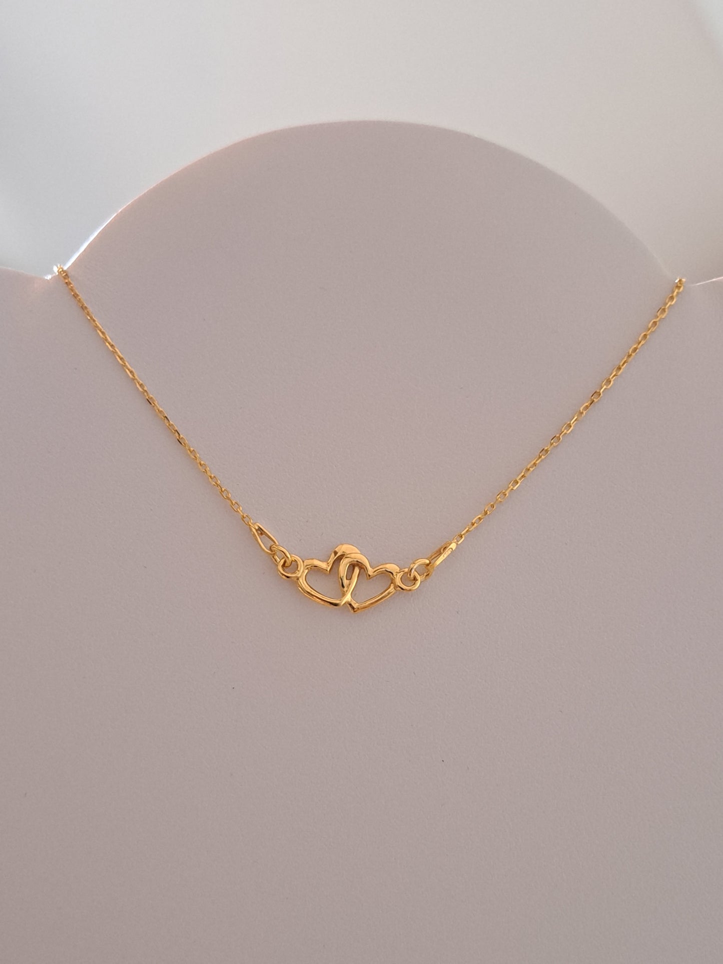 Collier doré motif double coeurs enlacés