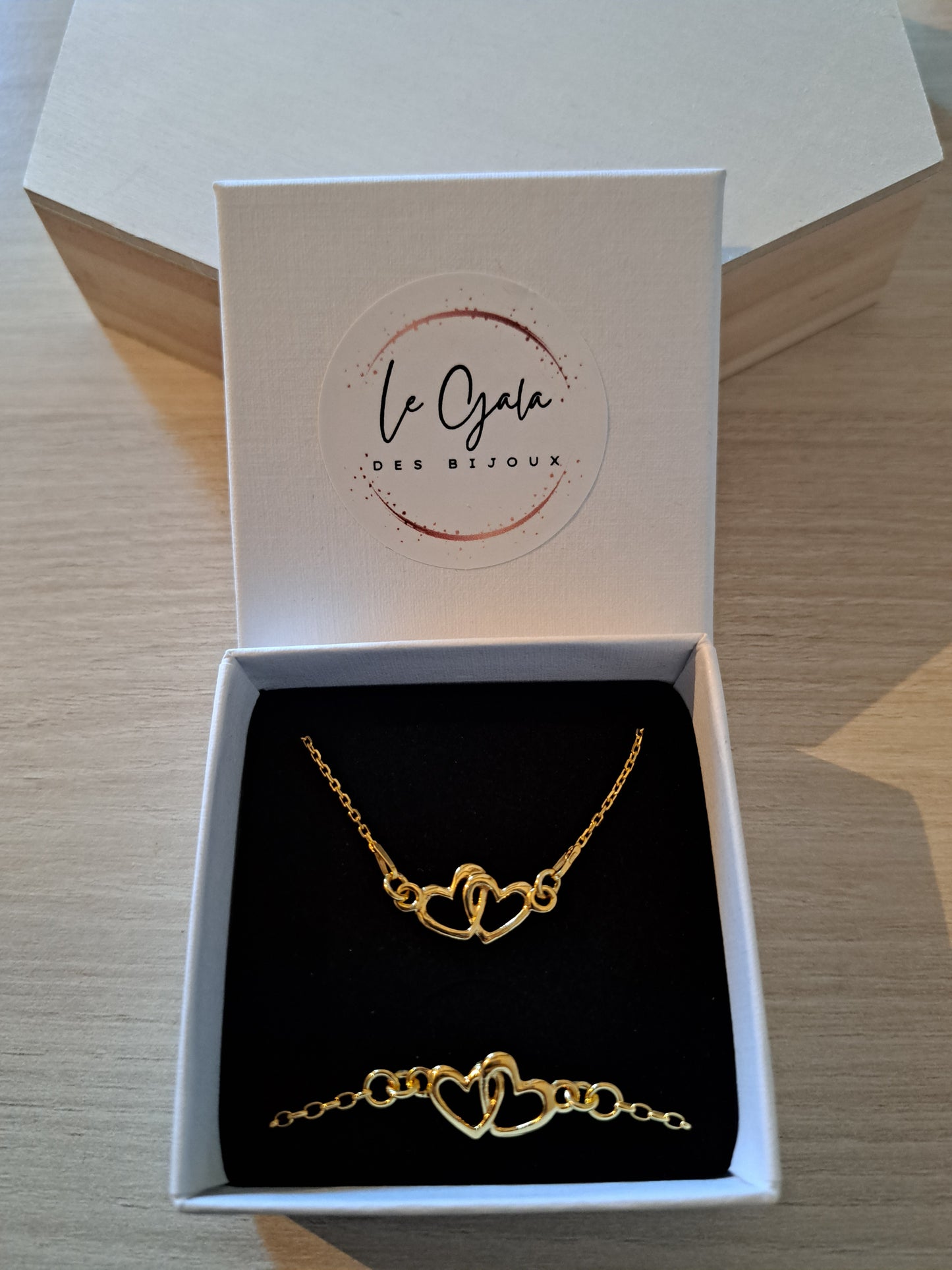 Parure collier et bracelet dorés motif double coeurs enlacés