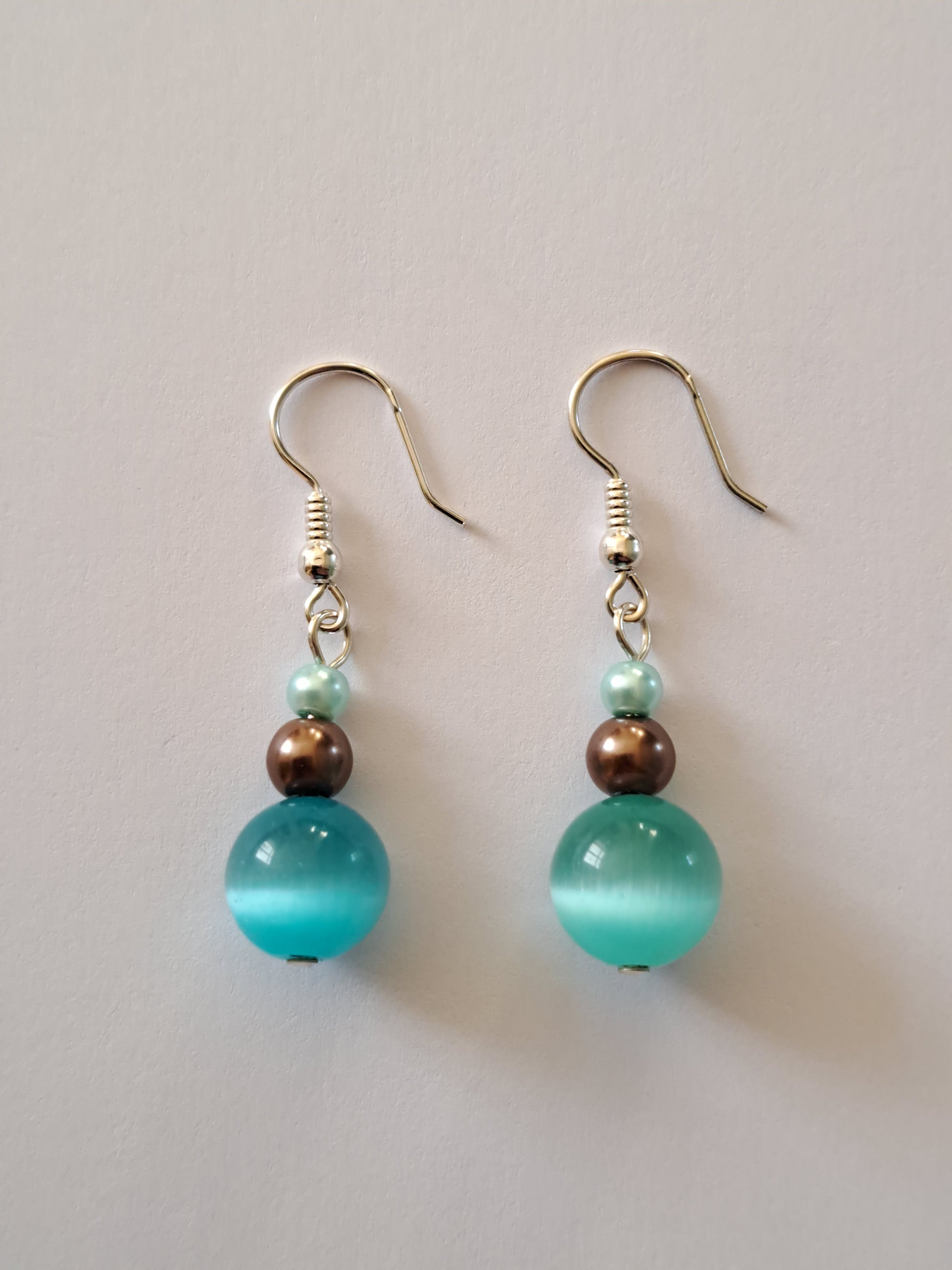 Boucles d'oreilles en argent avec perles nacrées et oeil de chat turquoise. Site de bijoux en ligne. France