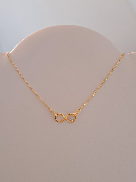 Collier doré symbole infini orné d'un cristal